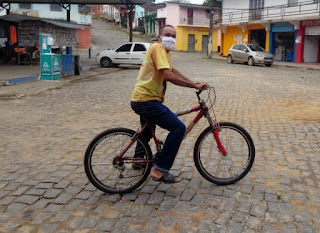GONGOGI:  DE BICICLETA, PADRE GENÁRIO ORIENTA POPULAÇÃO SOBRE A COVID-19.
